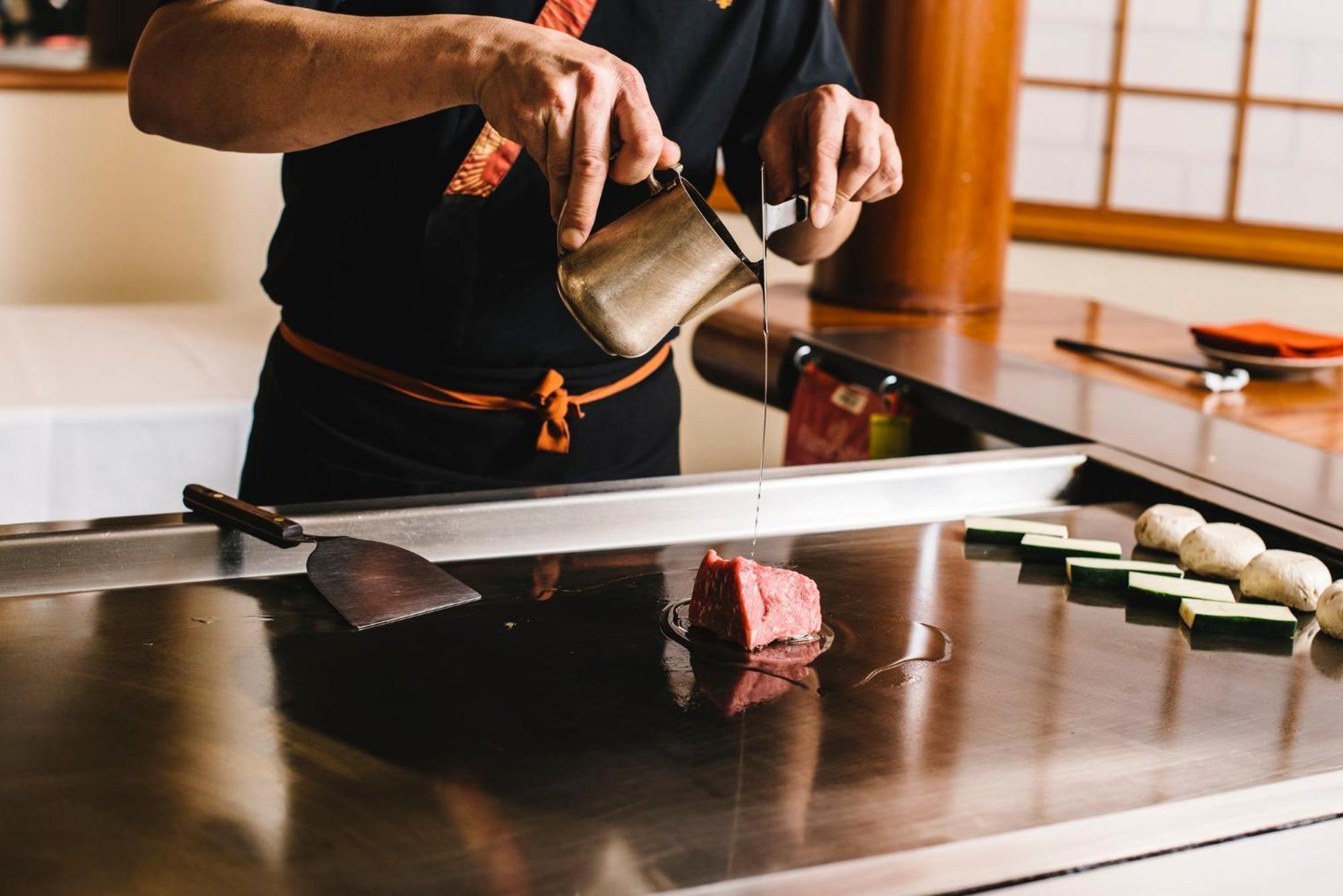 인터컨티넨탈 애들레이드 호텔 외부 사진 A sushi chef seasoning a piece of tuna